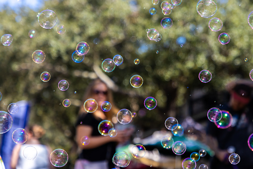 Soap bubbles fly through the air at a summertime festival to create a fun atmosphere.