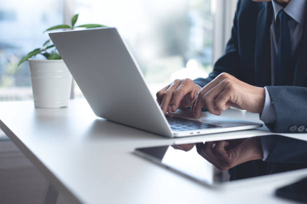 istock Businessman working on laptop computer with digital tablet on white office table 1432064288