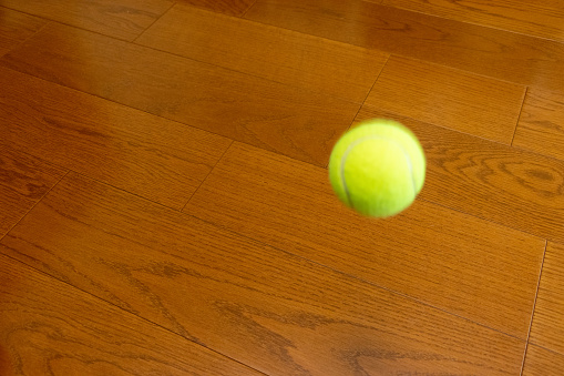 A tennis ball bouncing on the floor