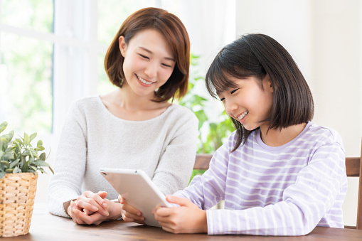 young asian mother and daughter,tablet computer
