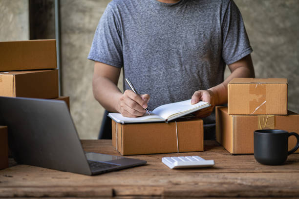 istock Operators work on receiving boxes and check online orders to prepare the packaging. Sell ​​to customers. SME business concept online e-commerce 1432084998