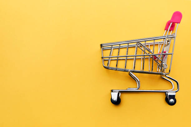 istock Shopping trolley on yellow background, close-up 1432088676