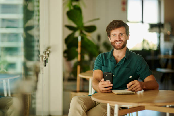 istock Owner, phone and notebook for cafe, coffee shop or Canada restaurant menu and pricing planning. Portrait, smile and happy man in food industry with mobile technology for ecommerce and website orders 1432095390