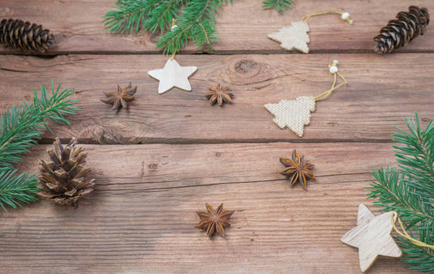 istock Top view of fir branch and cones on brown rustic table. Winter frame with coniferous branches. 1432096137