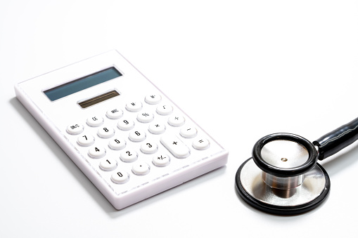 Stethoscope and calculator on white background.