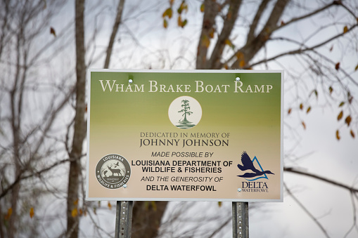 Wham Brake section of the Russell Sage Wildlife Management Area Louisiana/USA   December  17 2021: Sign marking the Wham Brake Boat Ramp, dedicating the ramp to the memory of Johnny Johnson, and noting that the ramp was made possible by Delta Waterfowl and the Louisiana Department of Wildlife and Fisheries