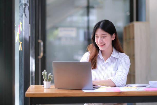 istock Asian Businesswoman Using laptop computer and working at office with calculator document on desk, doing planning analyzing the financial report, business plan investment, finance analysis concept. 1432109635