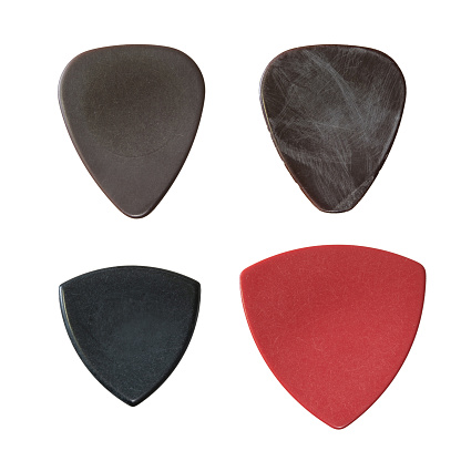 Old and new guitar picks on white background
