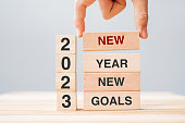 istock hand holding wooden block with text 2023 NEW YEAR NEW GOALS on table background. Resolution, strategy, solution, business and holiday concepts 1432113198