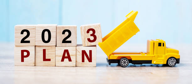 istock 2023 Plan cube blocks with miniature truck or construction vehicle. New Start, Vision, Resolution, goal, industrial, Warehouse and happy New Year concept 1432113307