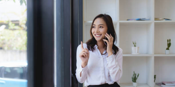 istock Asian businesswoman talking with client on mobile phone. 1432113436