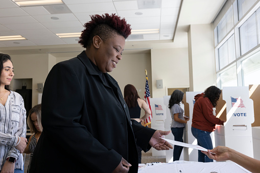 An African American woman voting at a local community center.