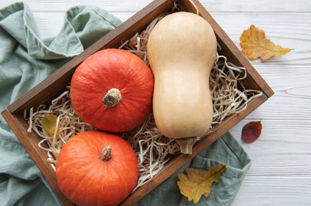 istock Autumn decorative pumpkins with fall leaves on wooden background. 1432118672