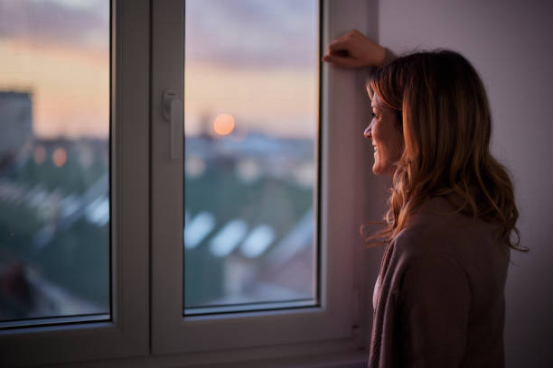 istock Happy woman day dreaming by the window. 1432119686
