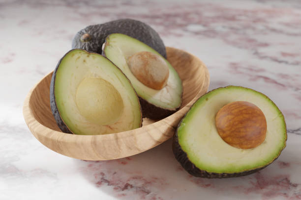 istock Fresh halved avocados in a bowl on a pink marble surface 1432119928