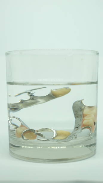 istock False tooth in a glass of water. 1432119983
