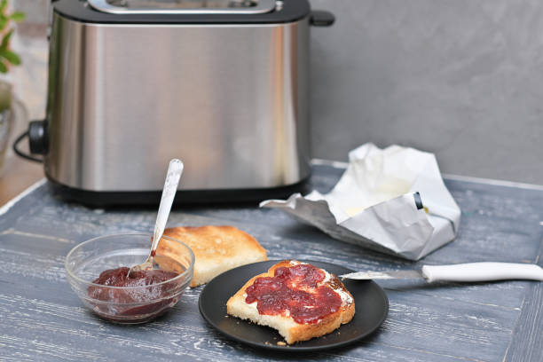 istock toasts with butter and berry jam on a wooden table next to toaster. breakfast time. 1432124231
