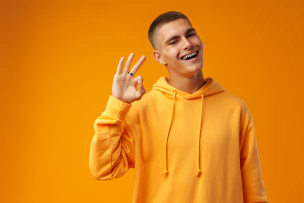 istock Happy young man gesturing OK sign against yellow studio background 1432129872