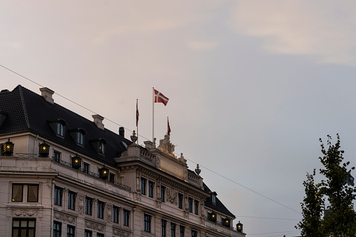 Copenhagen, Denmark. October 2022. The Danish flag flying on the roof of an ancient palace in the city center