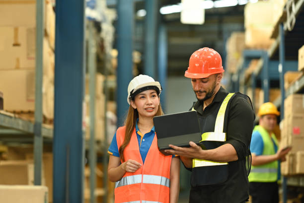 istock Male managers and worker checking newly arrived goods on digital tablet while standing near tall shelves in large warehouse. 1432135367