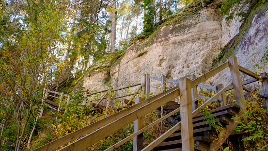 The large sandstone cliffs of Sietiniezis on the banks of the Gauja River in Latvia. tourist nature trail for hiking with wooden stairs. Gauja National Park in the vicinity of Valmiera, Autumn, October