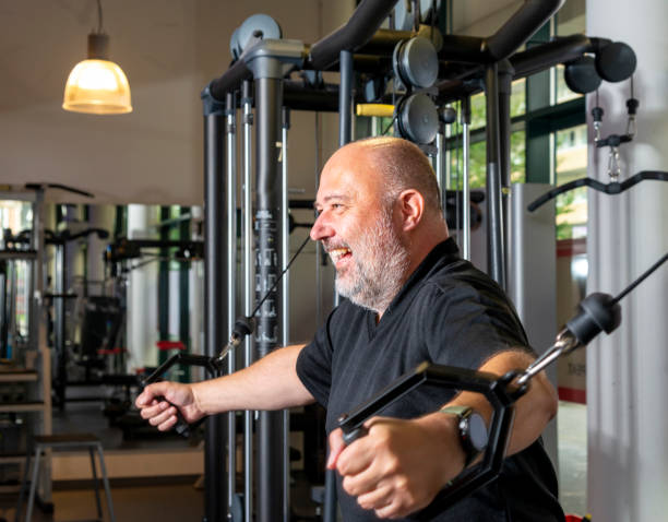 Portrait of middle aged man at his local gym. A   man does weight training at the gym. chest press stock pictures ripl fitness