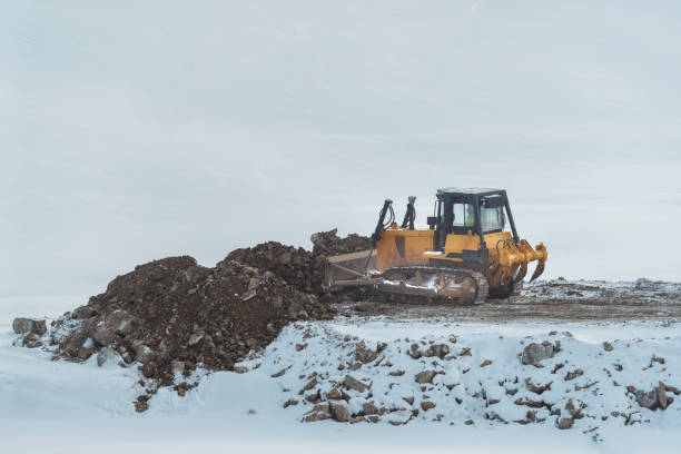 istock Bulldozer working on road construction site in grading phase in winter time 1432143693