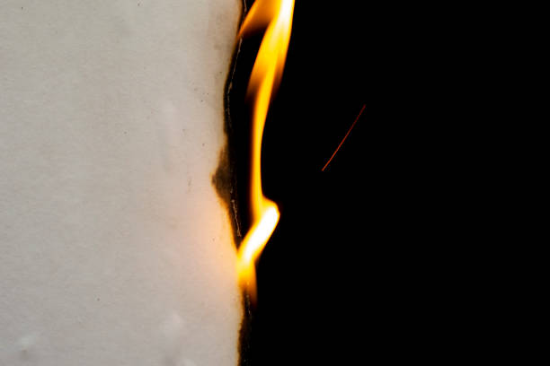 istock burning paper, glowing edge of paper on a black background 1432143820