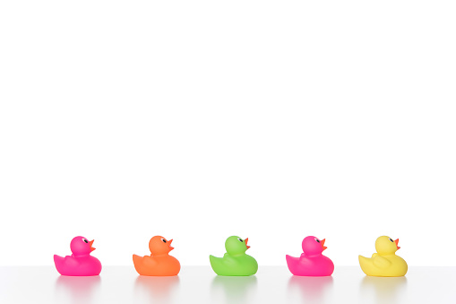 colorful Rubber Ducks in a line on a white background