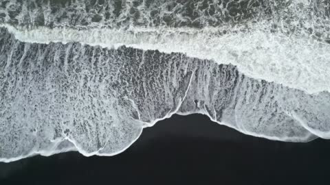 Top view of a black sand beach with waves in Iceland