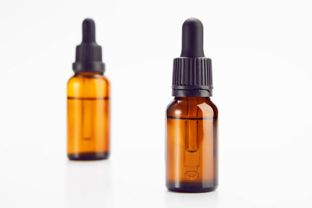 istock Two brown vials with black dropper caps isolated on white. 1432149020