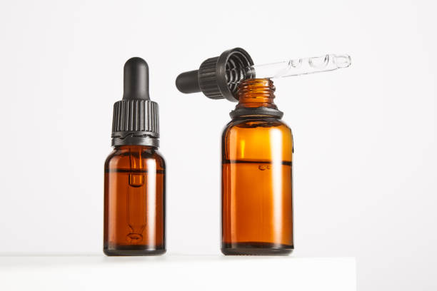 Two brown vials with black dropper caps isolated on white.