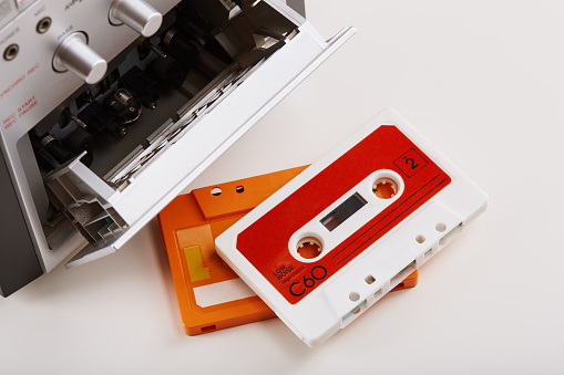 Blank cassette tape box on old wooden table background. Vintage cassette tape case with retro cassette mockup. Plastic analog magnetic clear packaging template. Mixtape box cover.