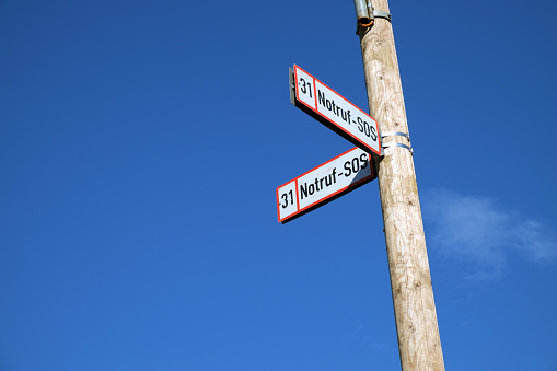 2 Notruf-SOS signs on a wooden pole