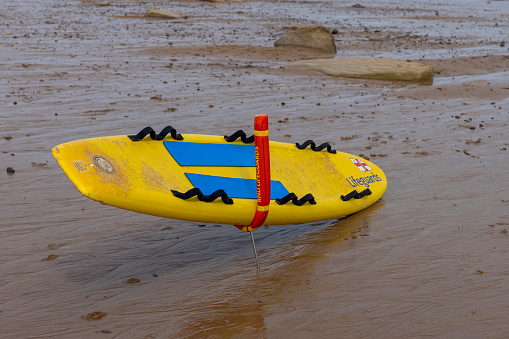 Whitley Bay beach and sea in the foreground is a lifeguard rescue surfboard . Whitley Bay, North East England, UK.