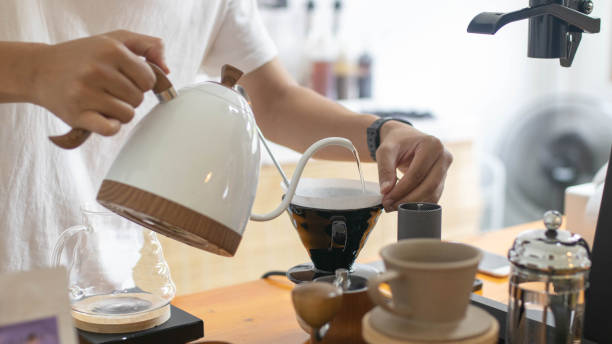 istock Barista is making drip brewing, filtered coffee, or pour over coffee with hot water and filter paper in coffee shop and drip kettle alternatives to coffee shop concept . 1432150949