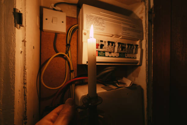 istock Senior man checking home fuse box by candlelight during power outage 1432151803