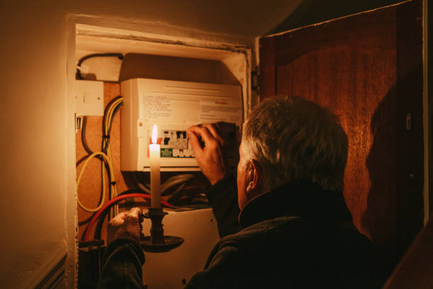 istock Senior man checking home fuse box by candlelight during power outage 1432151805