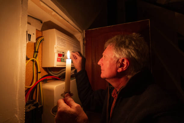 istock Senior man checking home fuse box by candlelight during power outage 1432151807