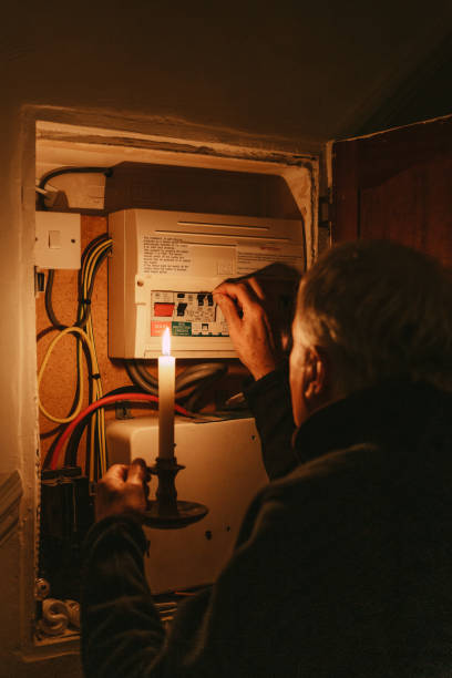 istock Senior man checking home fuse box by candlelight during power outage 1432151868