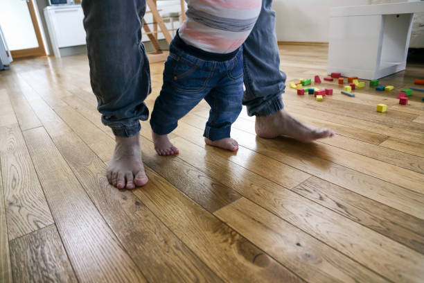 istock Father teaching baby to walk 1432155930