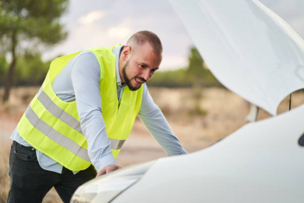 istock a man looking at the engine of his car wearing an emergency vest because it has broken down 1432157229