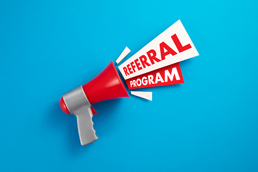 Red megaphone with referral program announcement on blue background