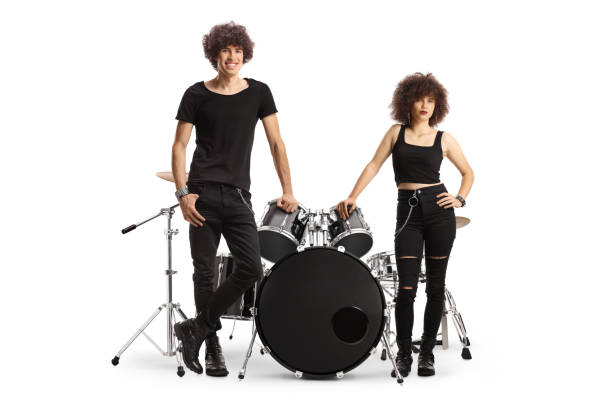 Young male and female drummer standing next to a drum kit and posing Young male and female drummer standing next to a drum kit and posing isolated on white background hair band stock pictures, royalty-free photos & images