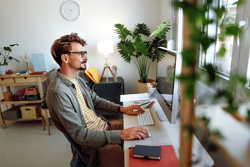 Young casually clothed man working from home