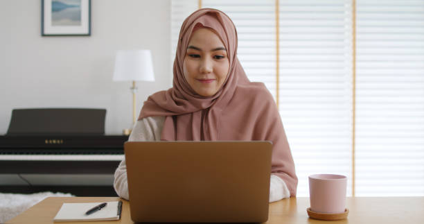 istock Young Gen Z workforce islam woman self learn MBA online class reskill upskill job at home. Asia people arab girl study relax sit at table wear hijab scarf write or typing e-mail work on digital laptop 1432161108