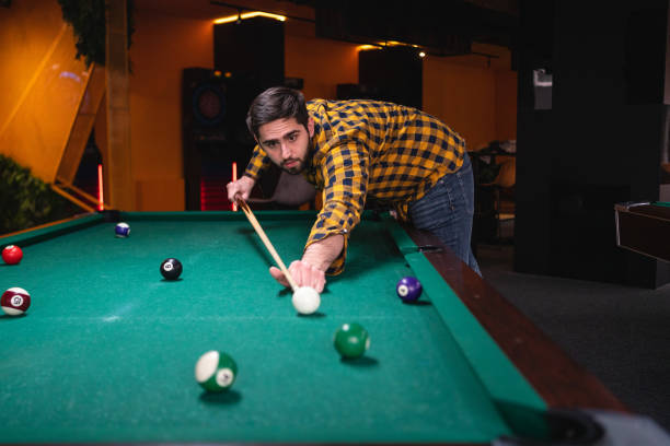 junger mann spielt billardtisch - pool game pool table aiming men stock-fotos und bilder