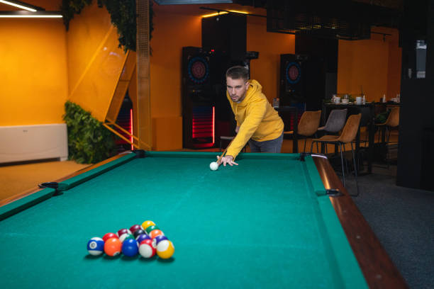 junger mann spielt billardtisch - pool game pool table aiming men stock-fotos und bilder