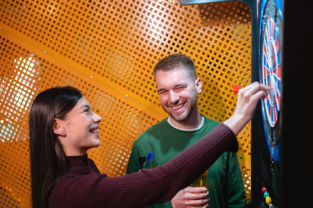 Young Caucasian couple playing darts together