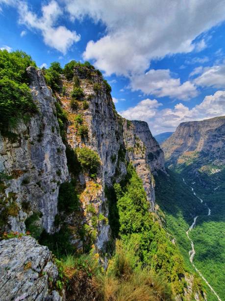 istock Mesmerizing view of rocky cliff with green plants under a cloudy blue sky 1432161840